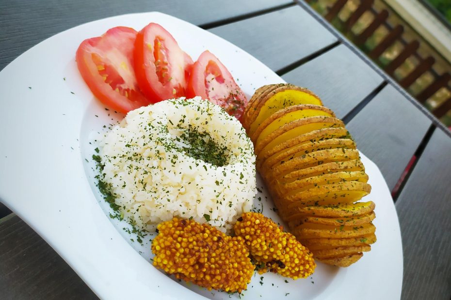 Hasselback burgonya köleskolbásszal, rizzsel és paradicsommal tálalva